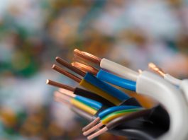 Las instalaciones eléctricas profesionales ganan importancia en nuevos proyectos Close-up of exposed copper wires with colored insulation from multi-conductor cables, held together against a blurred background
